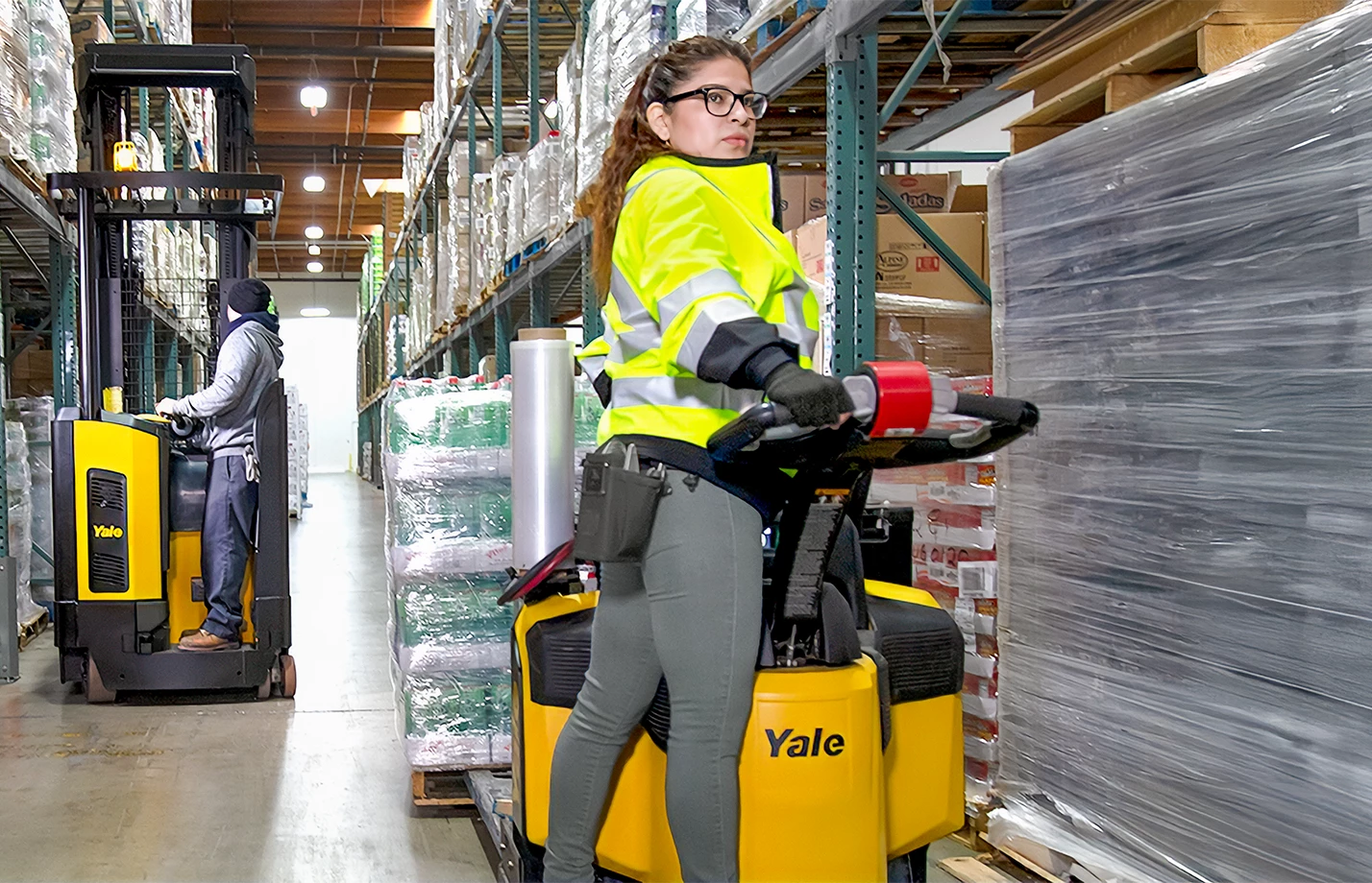 Yale reach truck and Yale end rider operating in warehouse facility.