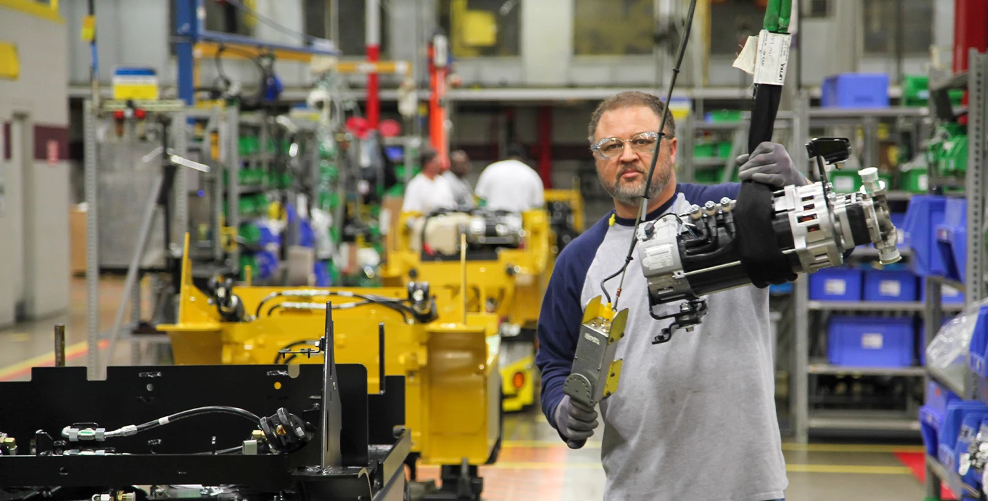Man assembling forklifts in HYMH manufacturing plant.