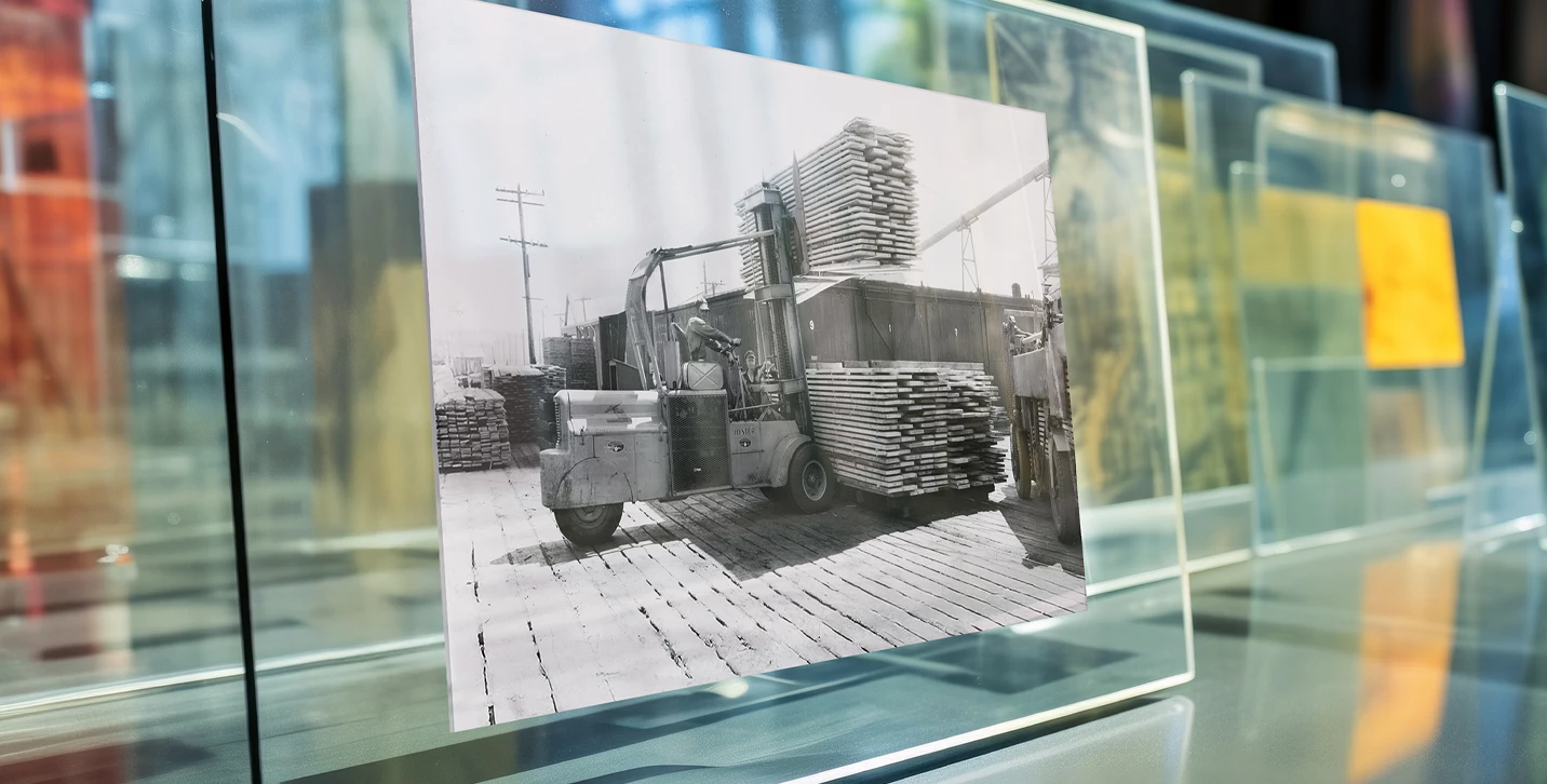 Photograph of 1930’s jumbo Hyster lift truck, sandwiched within glass frame, displayed in gallery. 