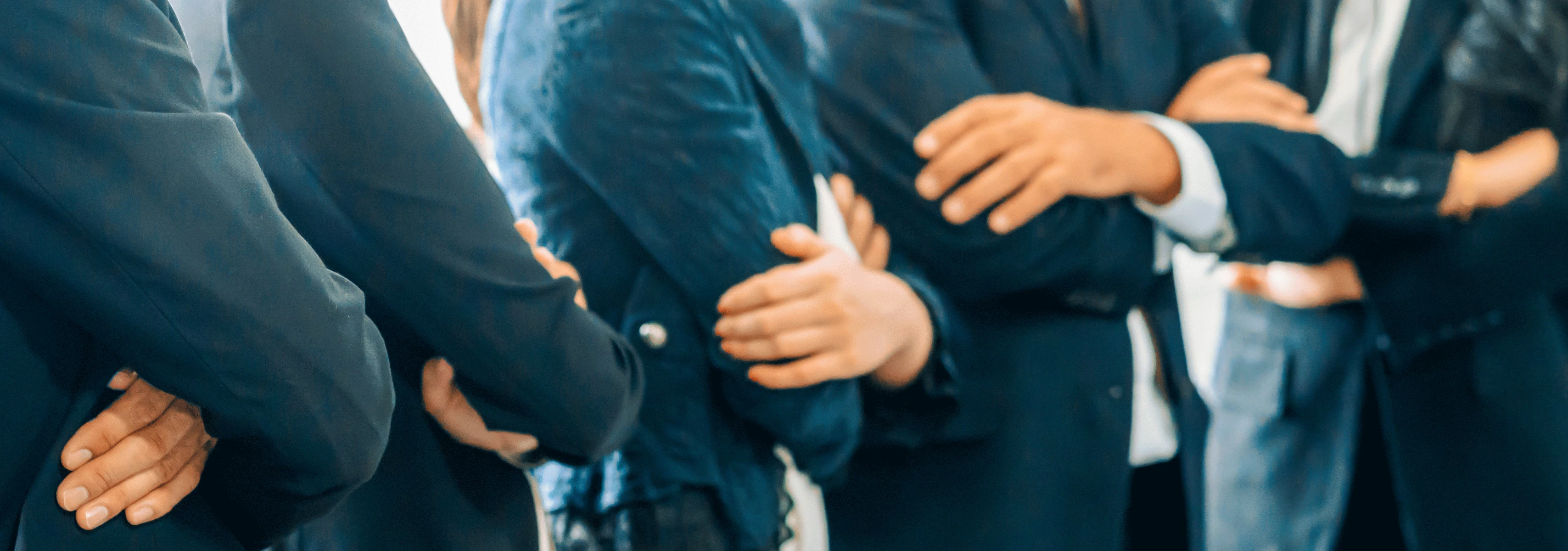 Corporate employees with folded arms.