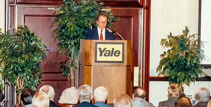Speaker at a conference standing behind podium.