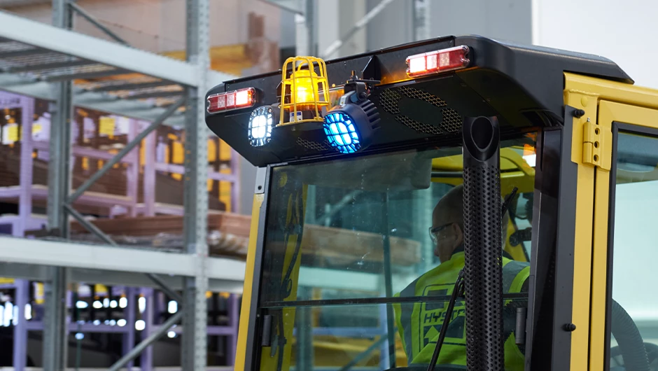 Forklift in warehouse with blue spotlight and other light options.